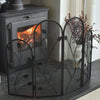 Wood-burning stove with decorative black metal fireplace screen in a home setting.