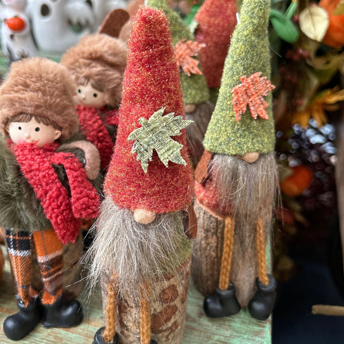 Decorative gnomes with autumn-themed clothing and accessories on a table.