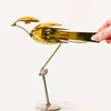 Gold bird-shaped fork sculpture on a white background
