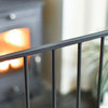Close-up of a metal railing with a fireplace and blurred background