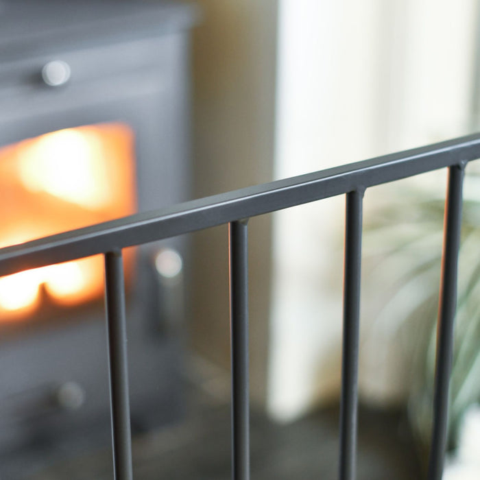 Close-up of a metal railing with a fireplace and blurred background