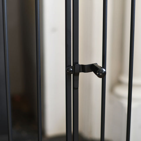 Close-up of a black metal gate with a blurred background