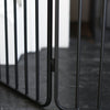 Close-up of a black metal gate with blurred background