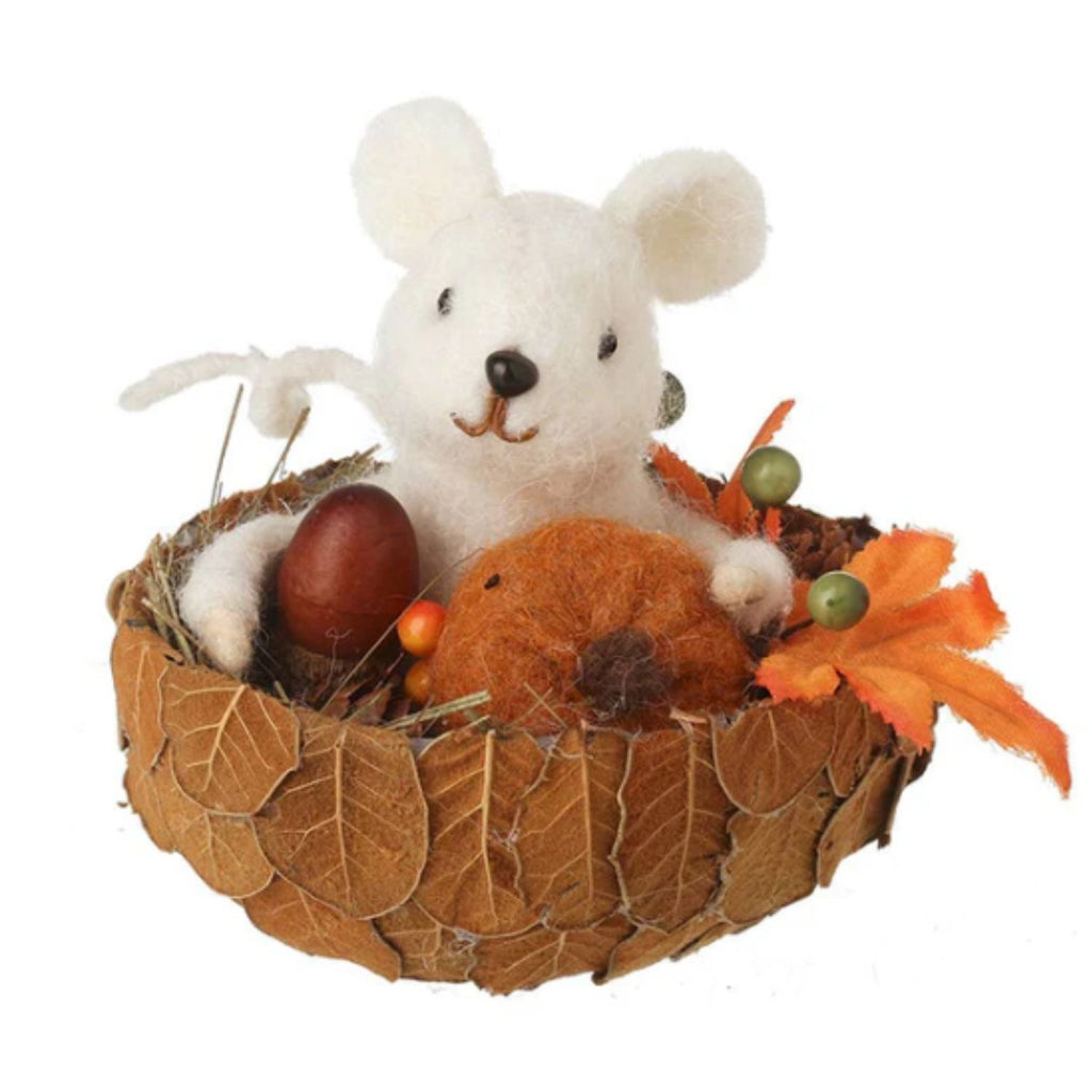 Decorative arrangement with felt mouse, an egg, and autumn leaves on a white background