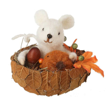 Decorative arrangement with felt mouse, an egg, and autumn leaves on a white background