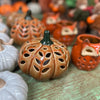 Ceramic pumpkins with various designs on a wooden surface