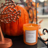 Orange cinnamon scented candle with decorative elements on a table