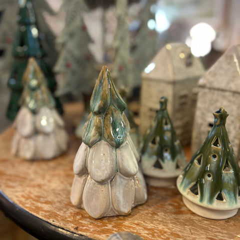 Collection of ceramic Christmas tree ornaments on a wooden surface.