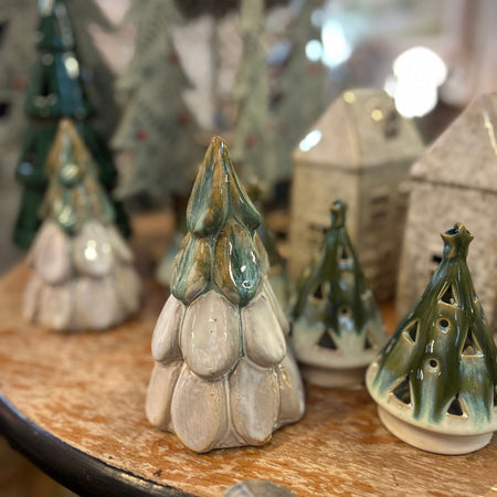 Collection of ceramic Christmas tree ornaments on a wooden surface.