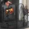 Person adjusting a decorative fireplace screen in front of a burning fireplace.