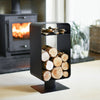 Black metal firewood holder with logs in front of a burning stove.