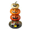 Stack of four Halloween pumpkins with carved faces on a white background