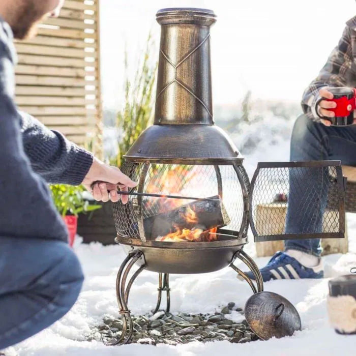 Man Burning Wood on Chimnea Fire Pit