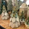 Collection of ceramic Christmas trees on a wooden surface with blurred background