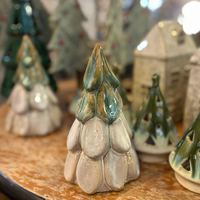 Collection of ceramic Christmas trees on a wooden surface with blurred background