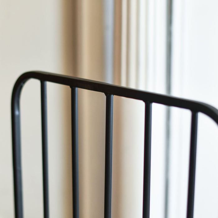 Close-up of a black metal bed frame against a neutral background