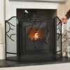 Black metal fireplace screen with decorative design over a lit fireplace.